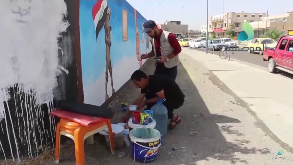 Volunteers paint over IS murals in Sumer neighborhood, East Mosul  