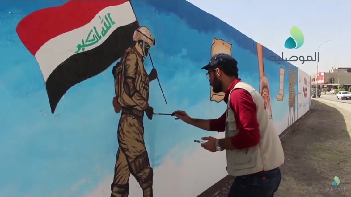 Volunteers paint over IS murals in Sumer neighborhood, East Mosul  