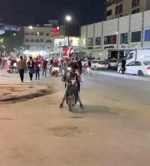 Iraq: Despite government imposed curfew in Baghdad, protesters visible in many streets holding the country's flag 