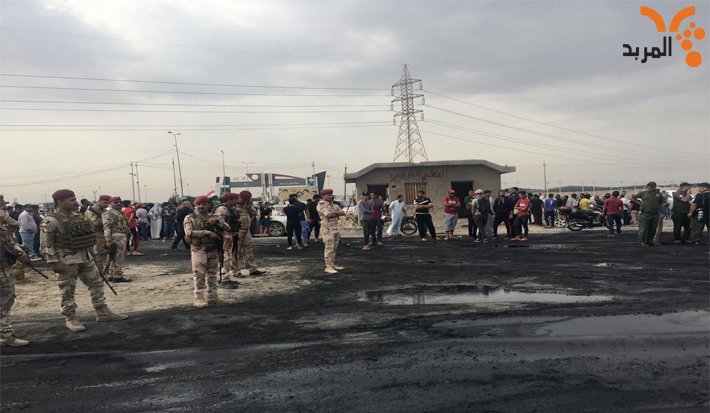 Demonstrators withdraw from the gate of the port of Umm Qasr after negotiations