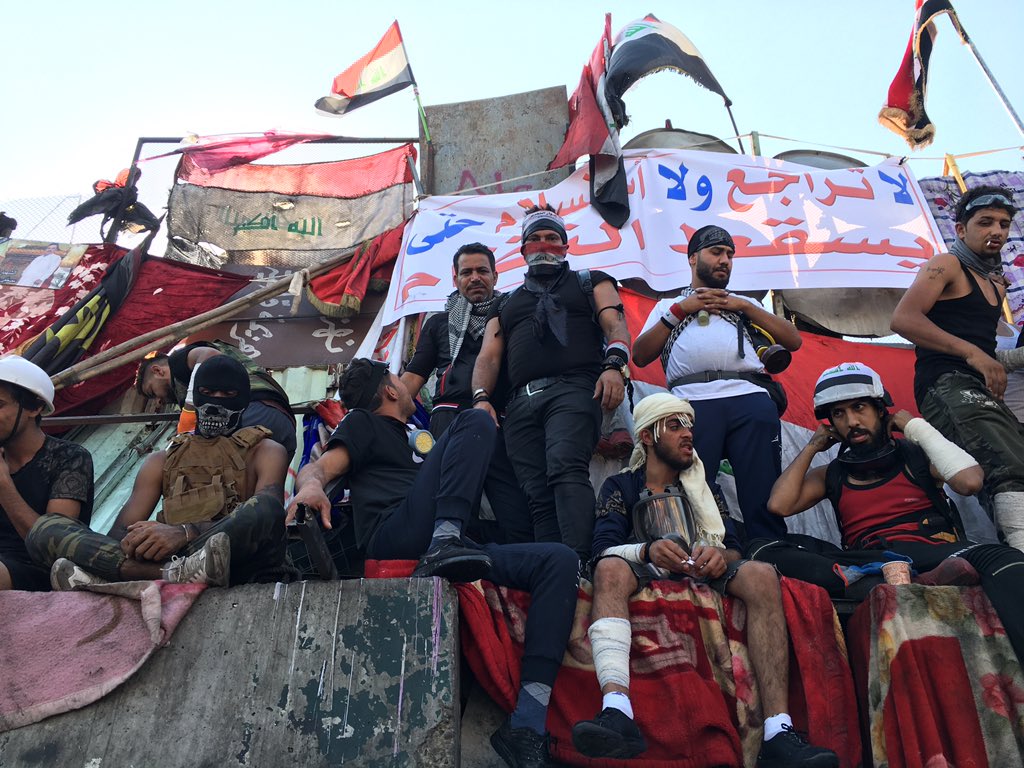 On Jumariyah bridge in Baghdad protesters sit on a makeshift barricade. At least six civilians were killed in the capital last night, when security forces opened fire. 