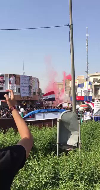 Government forces fire tear gas canisters at demonstrators in al-Haboubi Square in central Dhi Qar in southern Iraq