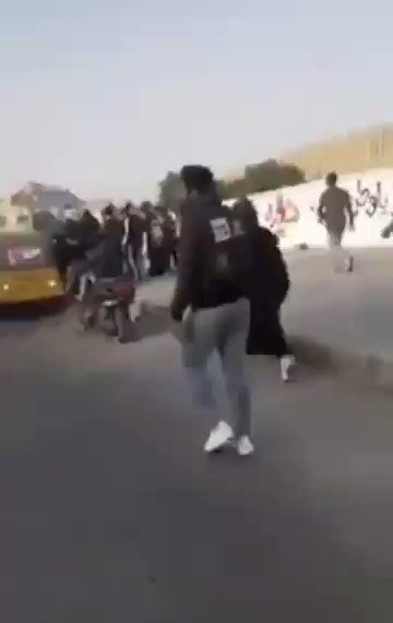 Demonstrators witness the assault by government forces on an activist in Karbala