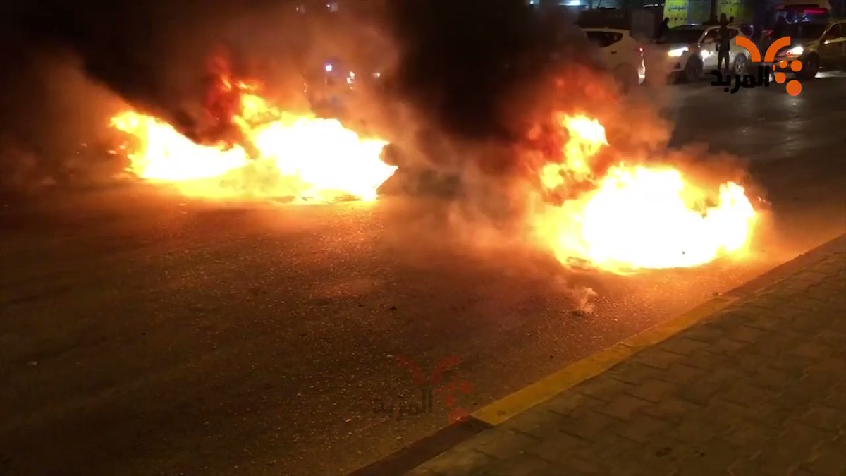 A number of demonstrators burn tires in Al-Tijari Street in Basra