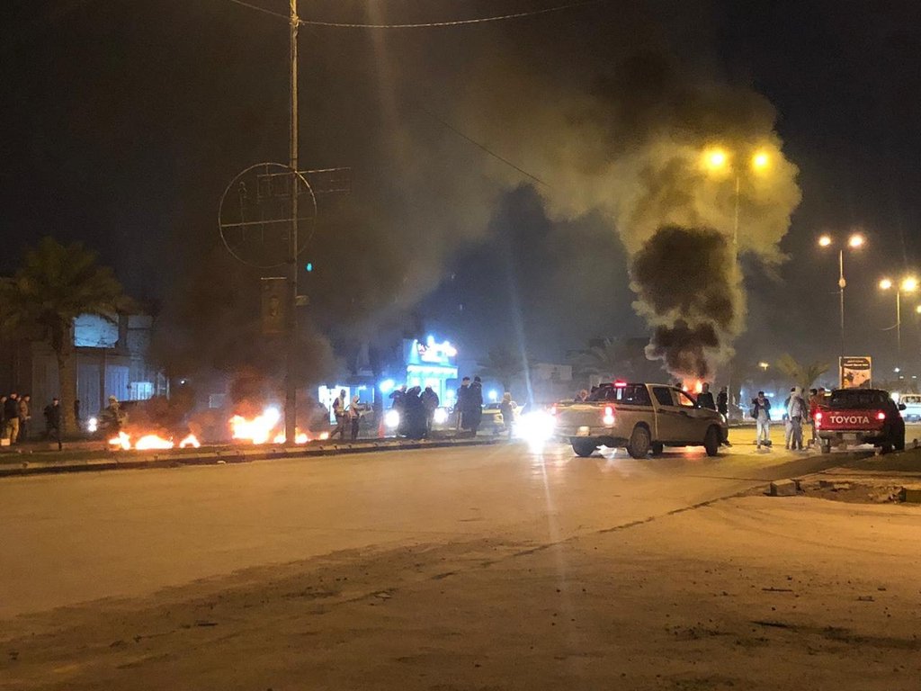 Masked men block the airport road in Najaf