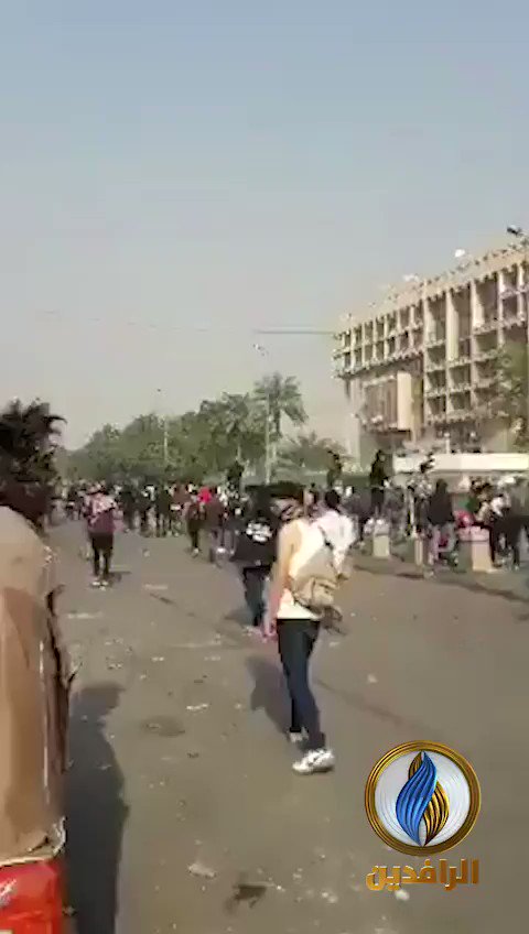 Security forces firing bullets and tear gas canisters at the demonstrators, near the Al-Khilani square in central Baghdad