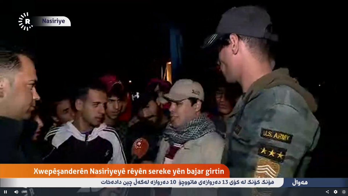 Protester wearing a coat having US ARMY badge on his hand tells @Rudawkurdish that security forces & Sadr's blue hats have been attempting to storm Haboubi Square in Nasiriyah city tonight, but foiled. Haboubi Square is the 2nd largest square in Iraq witnesses #IraqProtests